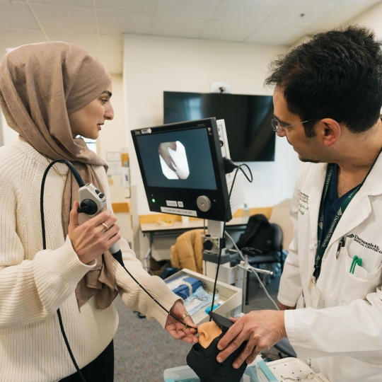 A student testing medical equipment on a dummy